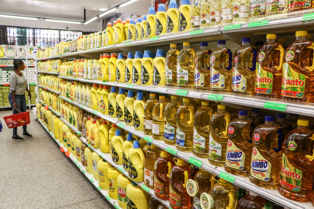 NAKURU, KENYA - 2024/03/11: A woman compares cooking oil prices at a supermarket in Nakuru City. Kenya's inflation rate declined to 6.3% in February, down from January's 6.9%, according to data from the Central Bank of Kenya (CBK). This marks a 23-month low, attributed to a decrease in the cost of essential foods and fuel. (Photo by James Wakibia/SOPA Images/LightRocket via Getty Images)